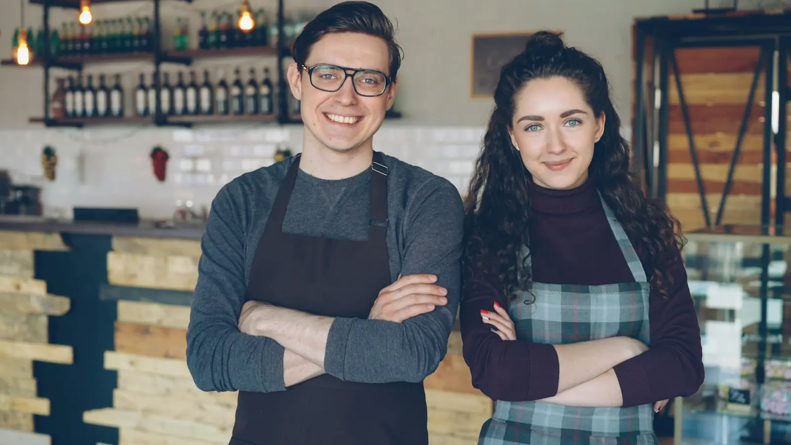 Two small business owners standing proudly in their cafe