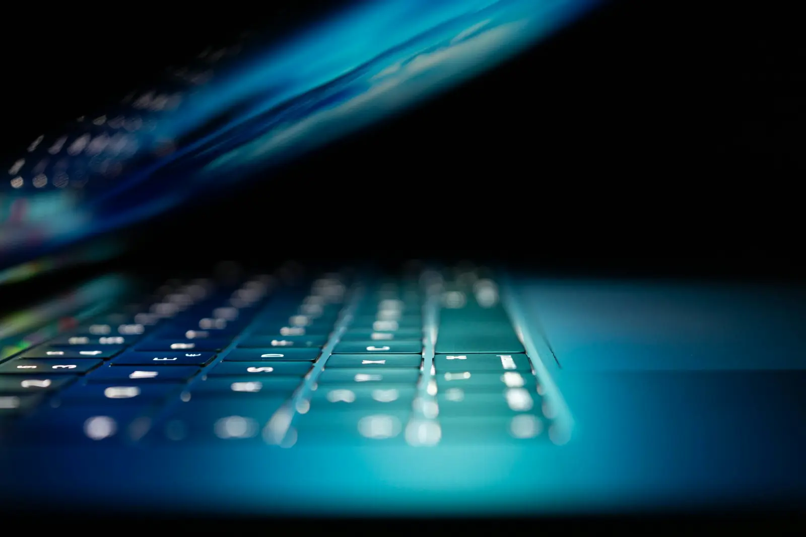 Close-up of a laptop keyboard glowing blue