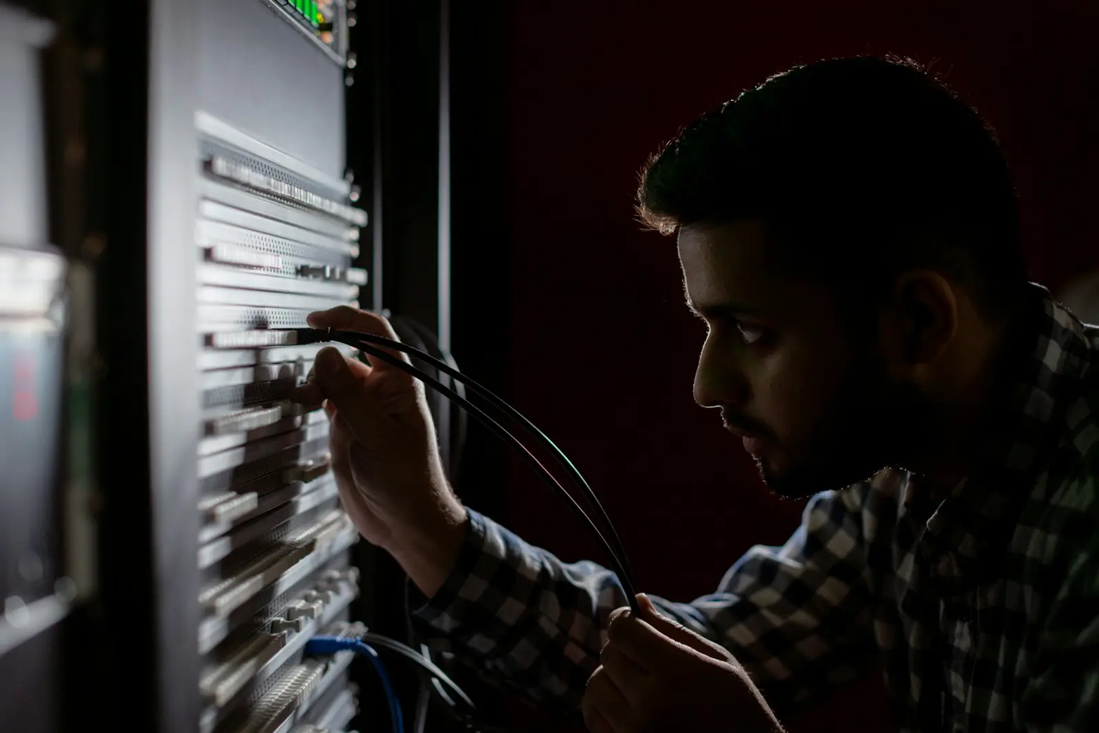 An engineer connecting cables in a server rack